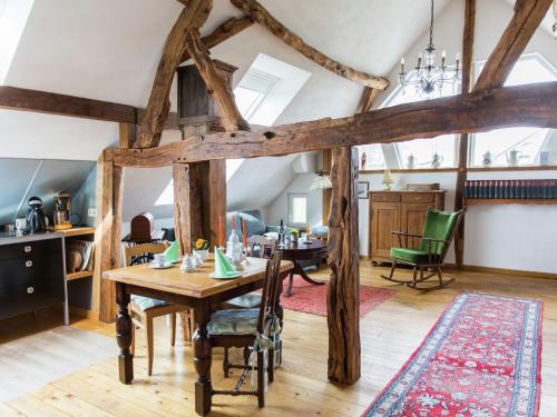 a dining room with a wooden table and green chairs at Schleiden Timber-Frame Retreat in Schleiden
