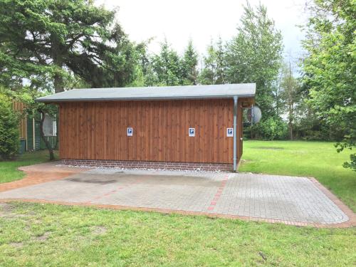 a brown building with a metal roof in a yard at Haus Hugo in Zingst