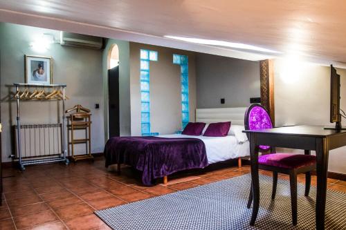 1 dormitorio con cama, mesa y escritorio en La Posada De La Magistral en Alcalá de Henares