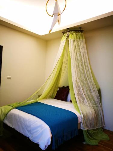a bed with a canopy in a room at 198紅帽民宿l市區l2025冷氣全面換新 in Magong