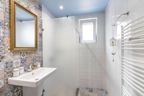 a white bathroom with a sink and a mirror at Domus Apartments City Center in Plovdiv