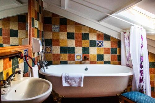 a bathroom with a tub and a sink at La Posada De La Magistral in Alcalá de Henares