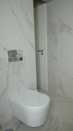 aseo blanco en un baño blanco con paredes de mármol en Ericeira penthouse with total sea view, en Ericeira