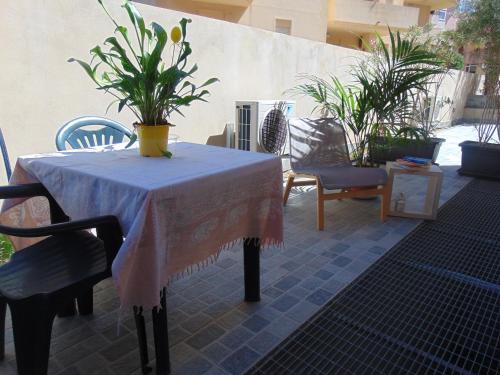 una mesa y sillas en un patio con plantas en Residence Le Isole, en Marsala