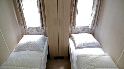 two beds in a small room with two windows at de Schelphoeve in Ellemeet