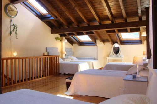 a bedroom with two beds in a room with skylights at Apartamentos San Antonio de Garabandal in San Sebastián de Garabandal
