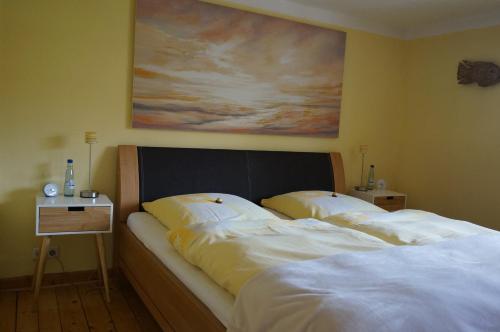 ボーデンヴェルダーにあるDas Fischerhausの壁に絵画が飾られた部屋のベッド2台