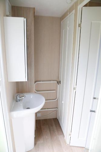 a white bathroom with a sink and a mirror at de Schelphoeve in Ellemeet