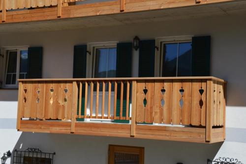 a wooden deck on the side of a house at La Lum De Roisc in Soraga