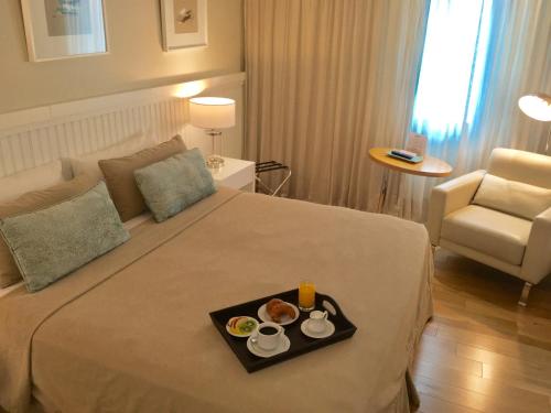a hotel room with a tray of food on a bed at Hotel Metropolitano Supara in Buenos Aires
