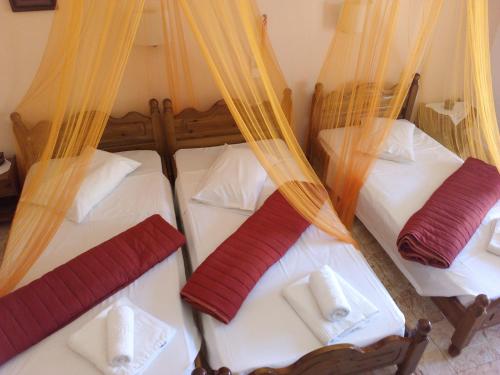 a group of four beds in a room at MARGARITAS' ROOMS in Agios Gordios