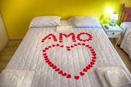 a heart made out of red beads on a bed at Pousada Ipitanga IV in Lauro de Freitas