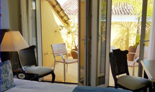 a bedroom with a bed and chairs on a balcony at Hotel Casa do Amarelindo in Salvador