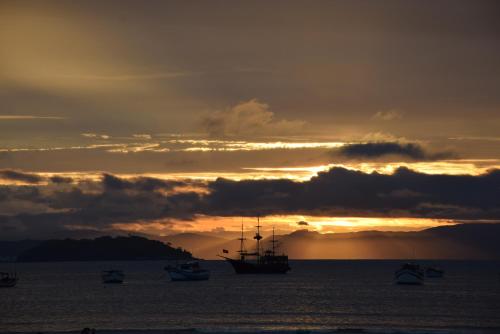 a group of boats in the water at sunset at Posada Sueños De Verano in Florianópolis
