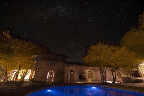 una casa con piscina por la noche en Hotel La Aldea, en San Pedro de Atacama