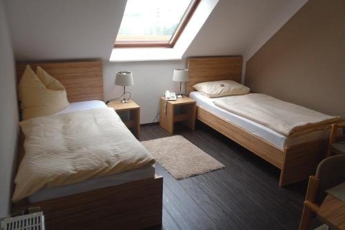 a small bedroom with two beds and a window at Osterberg - Restaurant und Hotel in Hildesheim