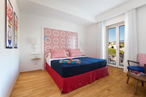 a bedroom with a blue and red bed and a window at Maison Kalea in Sorrento