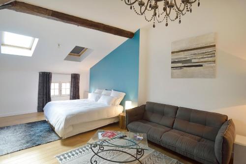 - une chambre avec un lit et un canapé dans l'établissement Les Apparts du Plot, au Puy-en-Velay