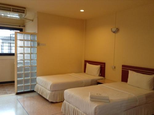 a hotel room with two beds and a window at Srisomthai Hotel in Ubon Ratchathani