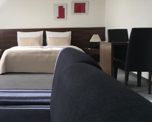 a bedroom with a bed and a desk and a chair at Penzion Luxor in Trnava