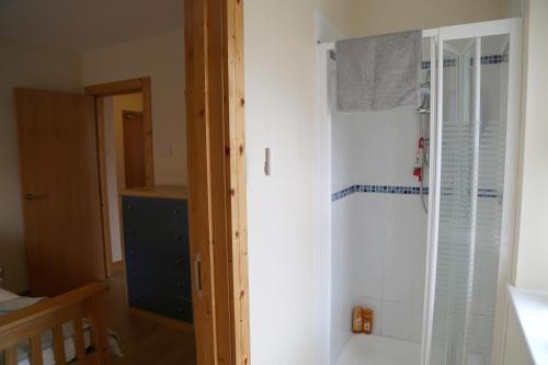 uma casa de banho com um chuveiro num quarto em Millstone Park Apartment em Portstewart