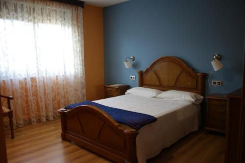 Un dormitorio con una cama grande y una ventana en O Curruncho dos Lopez, en Mazaricos