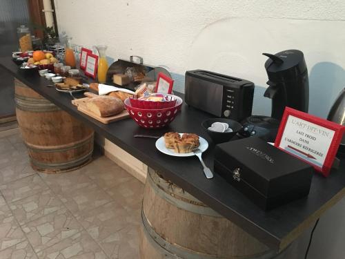 eine Theke mit einem Tisch, auf dem Essen und ein Teller mit Essen stehen in der Unterkunft L'Art Dit Vin in Saint-Aigulin