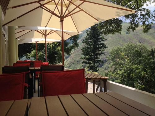 a patio with tables and chairs and an umbrella at Hotel Rural Misarela in Geres