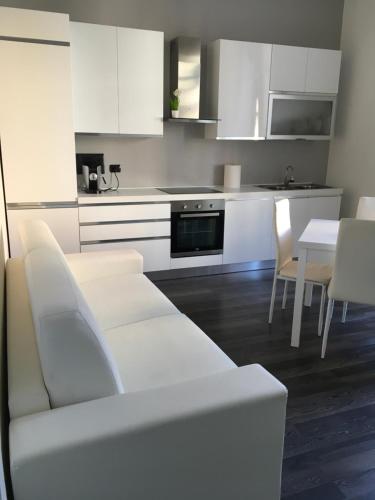 eine weiße Küche mit einem weißen Sofa und einem Tisch in der Unterkunft Civico 14 in Reggio di Calabria