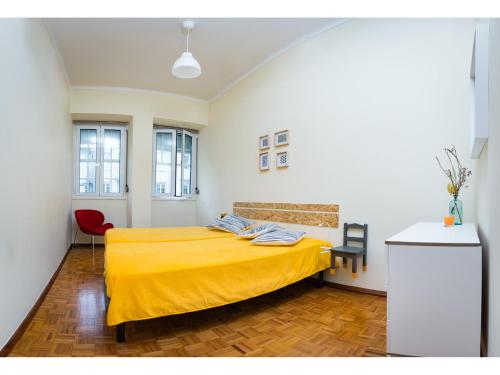 a bedroom with a bed with a yellow blanket at Downtown Shelter - Casa da Praça in Aveiro
