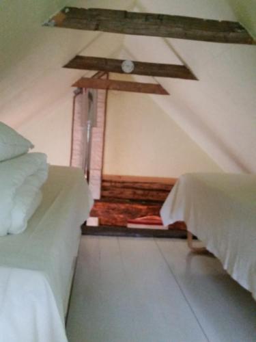 a room with two beds and a ceiling at Ranna Villa Farm in Küdema