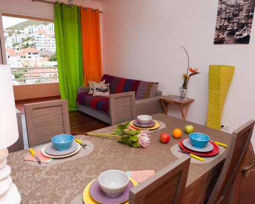 a living room with a table with dishes on it at Apartamento Funchal Sunshine in Funchal