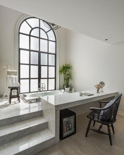 a bathroom with a large sink and a chair at Hotel Once Bangkok in Bangkok
