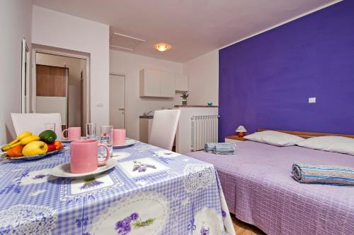 a room with two beds and a table with fruit on it at Apartments Roko in Rovinj