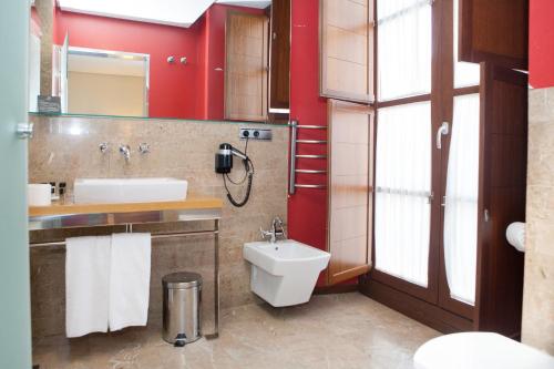 a bathroom with a toilet and a sink at Soho Boutique Casa Don Fernando in Cáceres