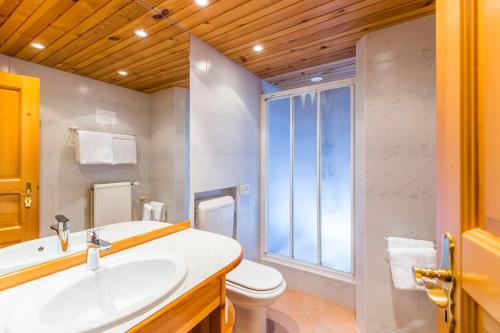 uma casa de banho com um lavatório, um WC e uma janela. em Penzion Berc em Bled