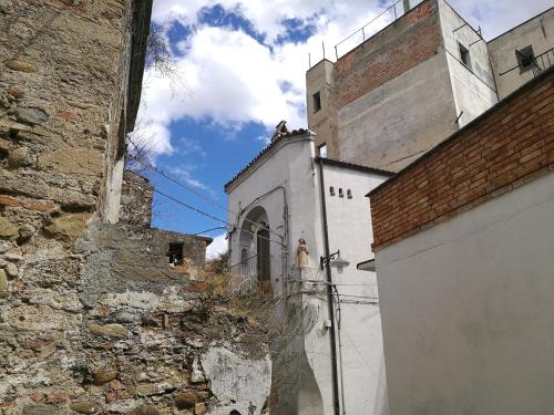 a white building with a brick wall next to a building at Planet casa vacanze in Montalbano Jonico
