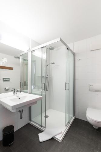 a bathroom with a shower and a sink and a toilet at Hotel Spree-idyll in Berlin