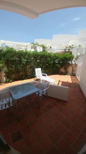a patio with a table and a chair and a hot tub at Hotel las Calas in Agua Amarga