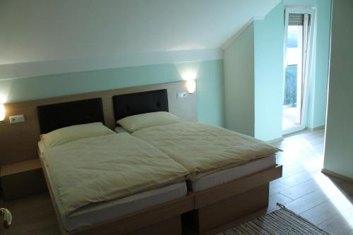 Schlafzimmer mit einem großen Bett mit einem Kopfteil aus Holz in der Unterkunft Penzion Gostisce Lesjak in Orehova vas 