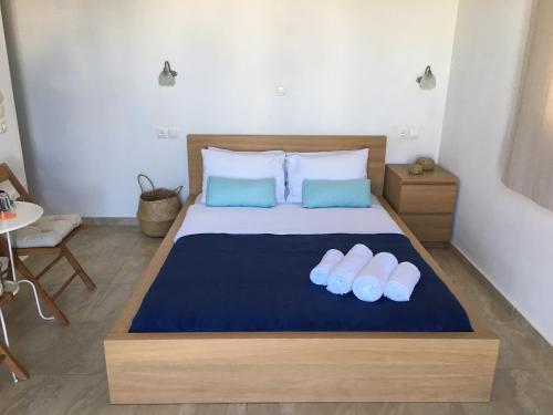 Gaia Serifos Apartments في Rámos: غرفة نوم بسرير كبير مع وسادتين