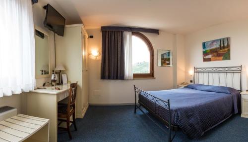 a bedroom with a bed and a sink and a window at Villa San Giorgio in SantʼAmbrogio di Valpolicella