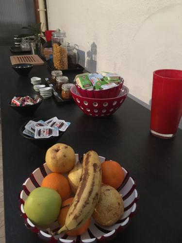 einen Tisch mit einer Schale Obst auf einem Tisch in der Unterkunft L'Art Dit Vin in Saint-Aigulin