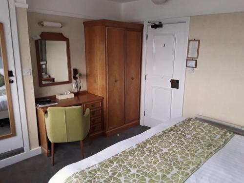 a bedroom with a bed and a desk and a mirror at The Cottage Hotel in Hope-Cove