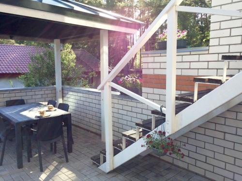 an outdoor patio with a table and a staircase at Guest House Rannaliiv in Võsu
