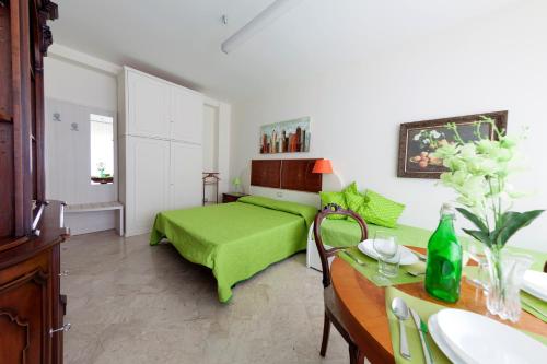 馬泰拉的住宿－La Quintessenza，一间卧室配有一张绿色的床和一张带水槽的书桌