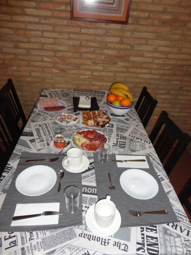 a table with plates of food and a bowl of fruit at B&B "Domus Atilia" in Sagunto