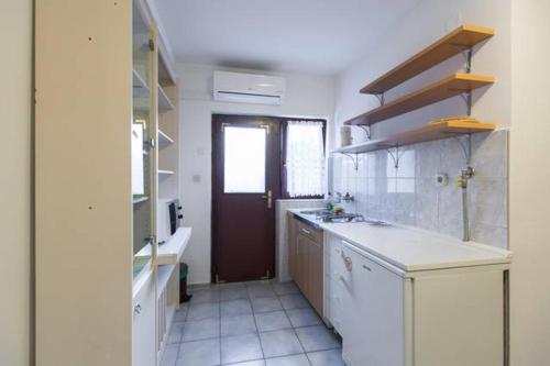 a kitchen with a sink and a door in it at Apartments Maximir in Zagreb