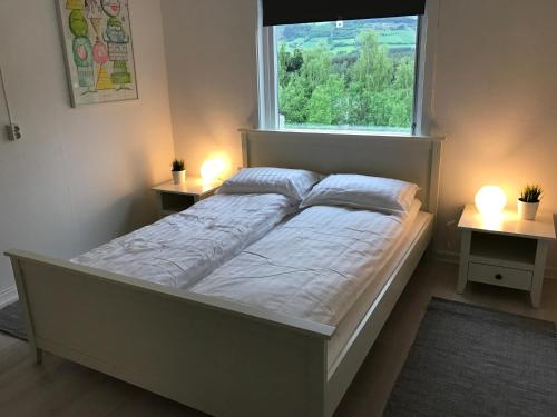 un letto in una camera con finestra e due lampade di Vinstra Hostel a Vinstra