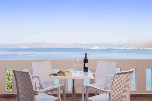 a white table with chairs and a bottle of wine at Balos Beach in Kissamos